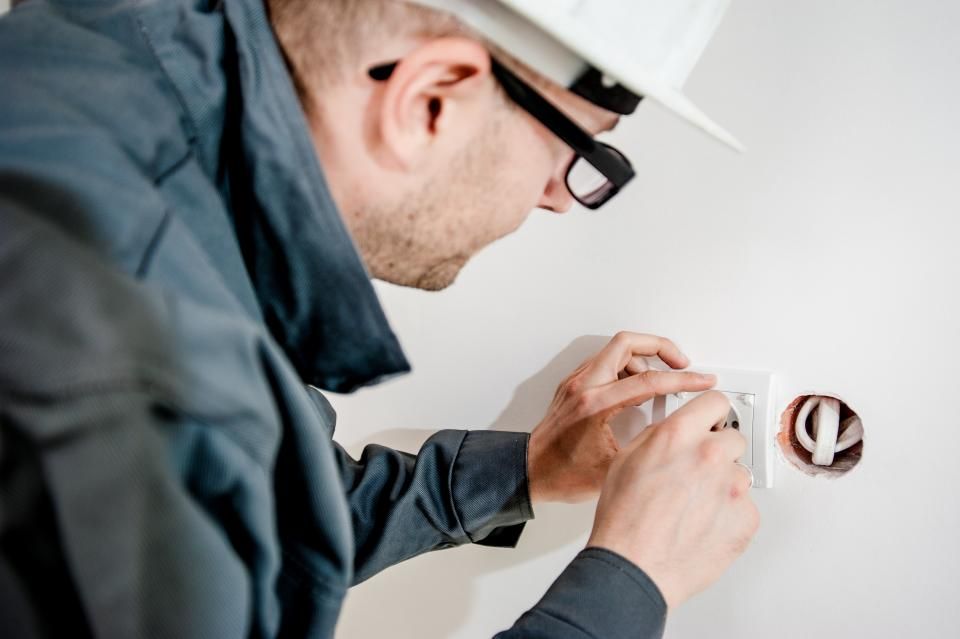 Técnico instalando una conexión en la pared de una casa